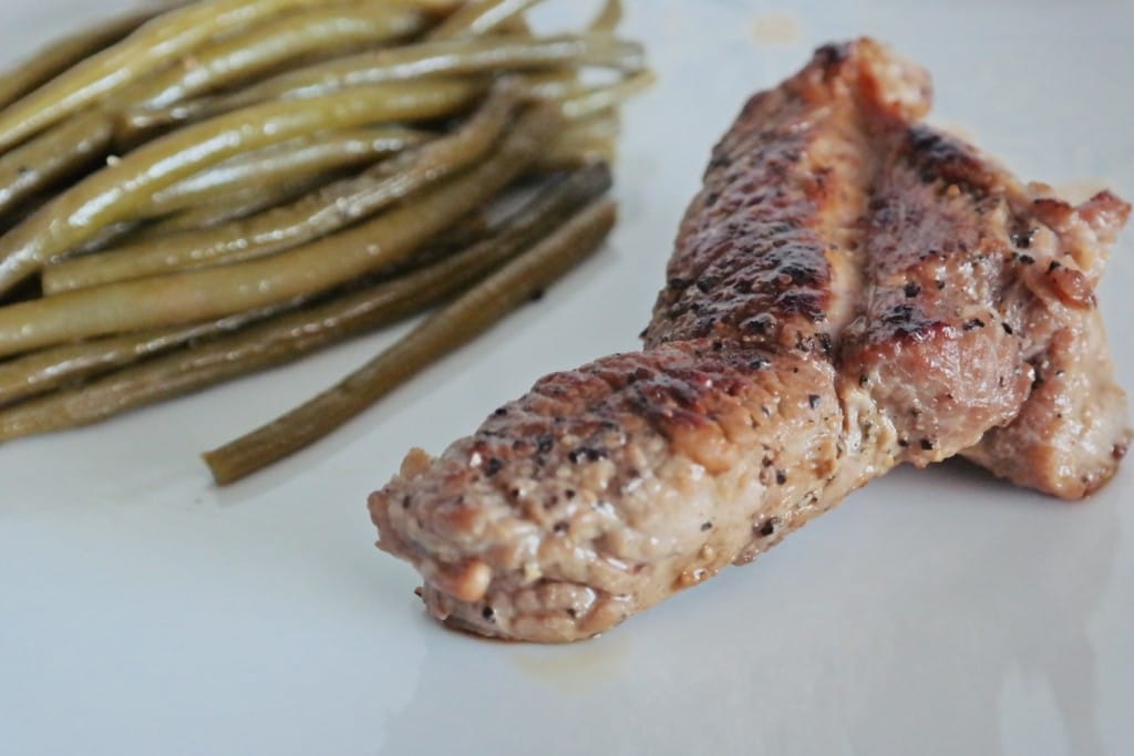 A plate of beef steak and green beans