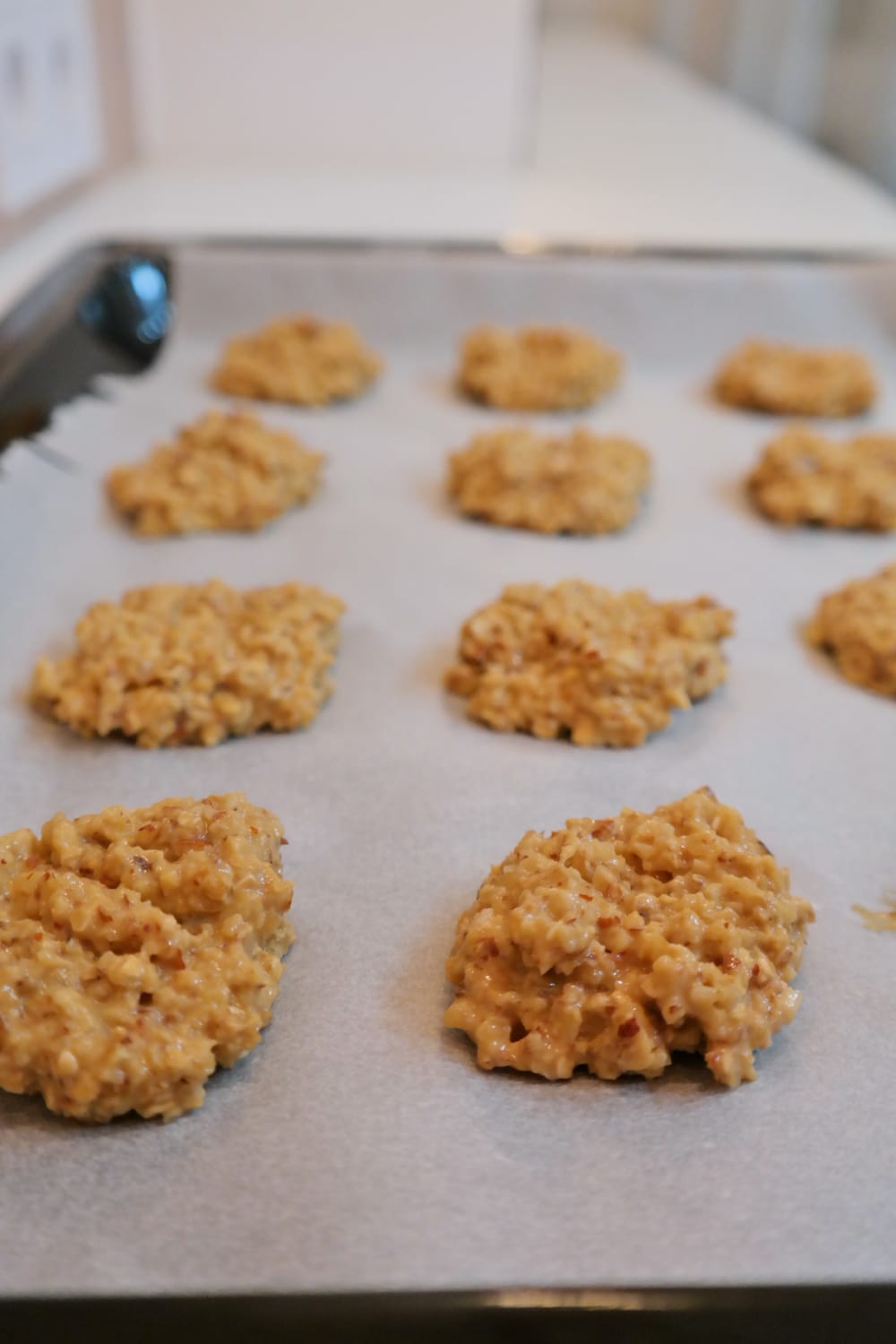 Oat and walnut cookies on a baking tray before baking