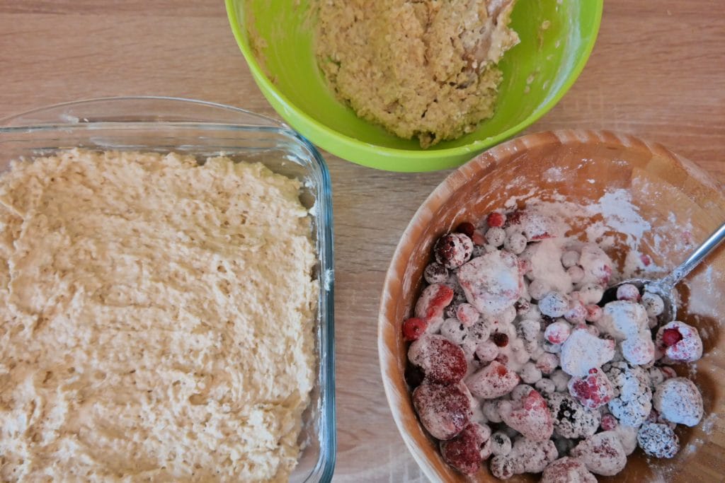 Baza de aluat cu ovaz in tava si fructe de padure congelate pregatite pentru prajitura crumble
