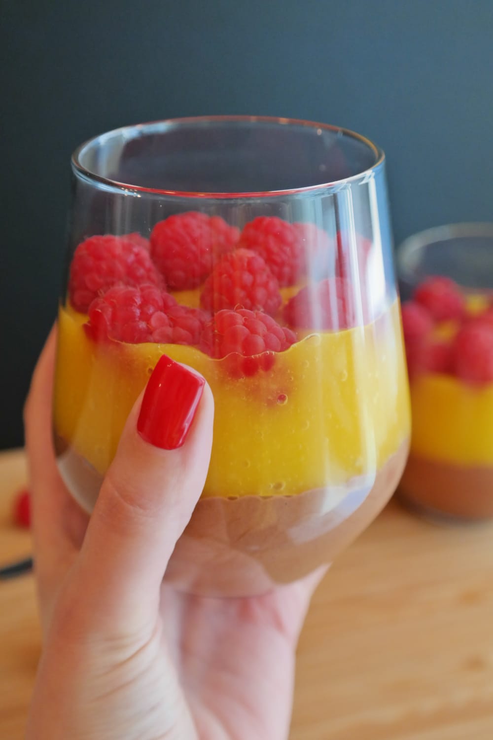 Pahar cu mousse de ciocolată, strat de piure de mango și zmeură proaspătă