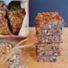 Stack of no-bake pumpkin seed and sunflower seed chocolate bars on a wooden board
