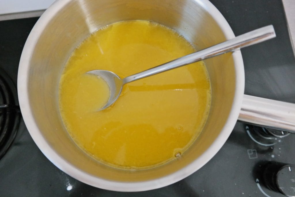 Fresh orange juice heating in a saucepan for making orange jelly