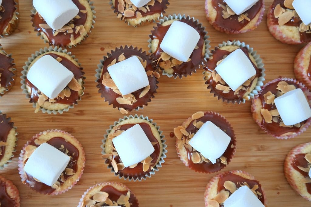 Caramel cupcakes with sliced almonds topped with marshmallows before toasting