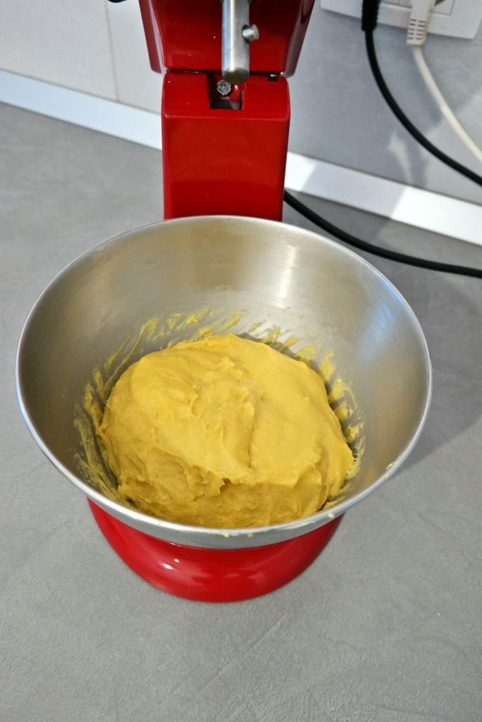 Soft, smooth, and elastic cinnamon roll dough formed into a ball inside the stainless steel stand mixer bowl after kneading.