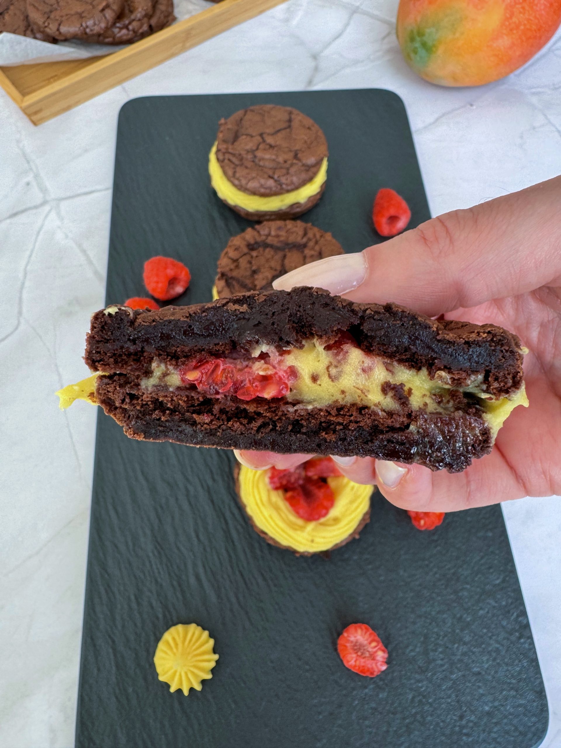 Brownie cookies stuffed with mango ganache and fresh raspberry