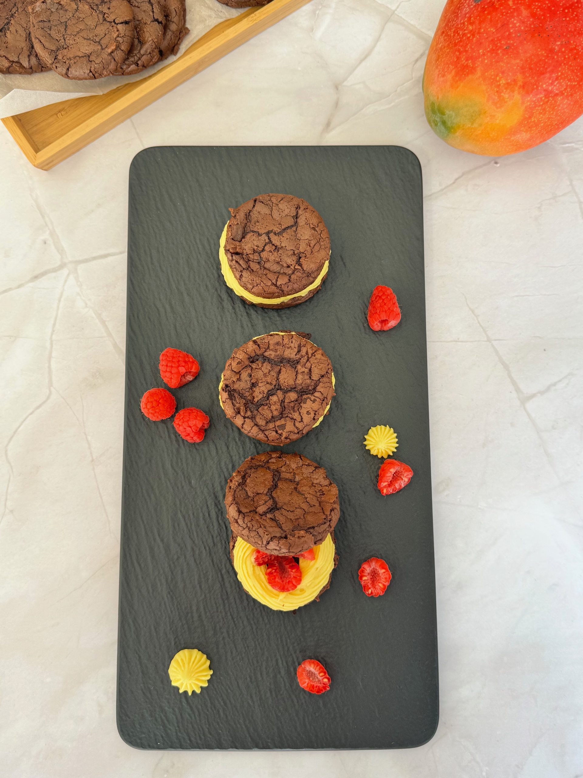 Biscuiti sandwich brownie cu ganache de mango si zmeura