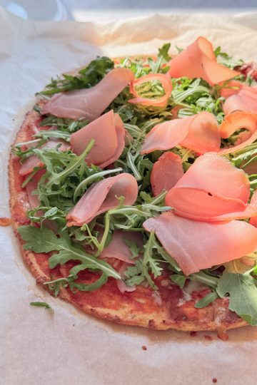 High-protein pizza with prosciutto crudo and arugula
