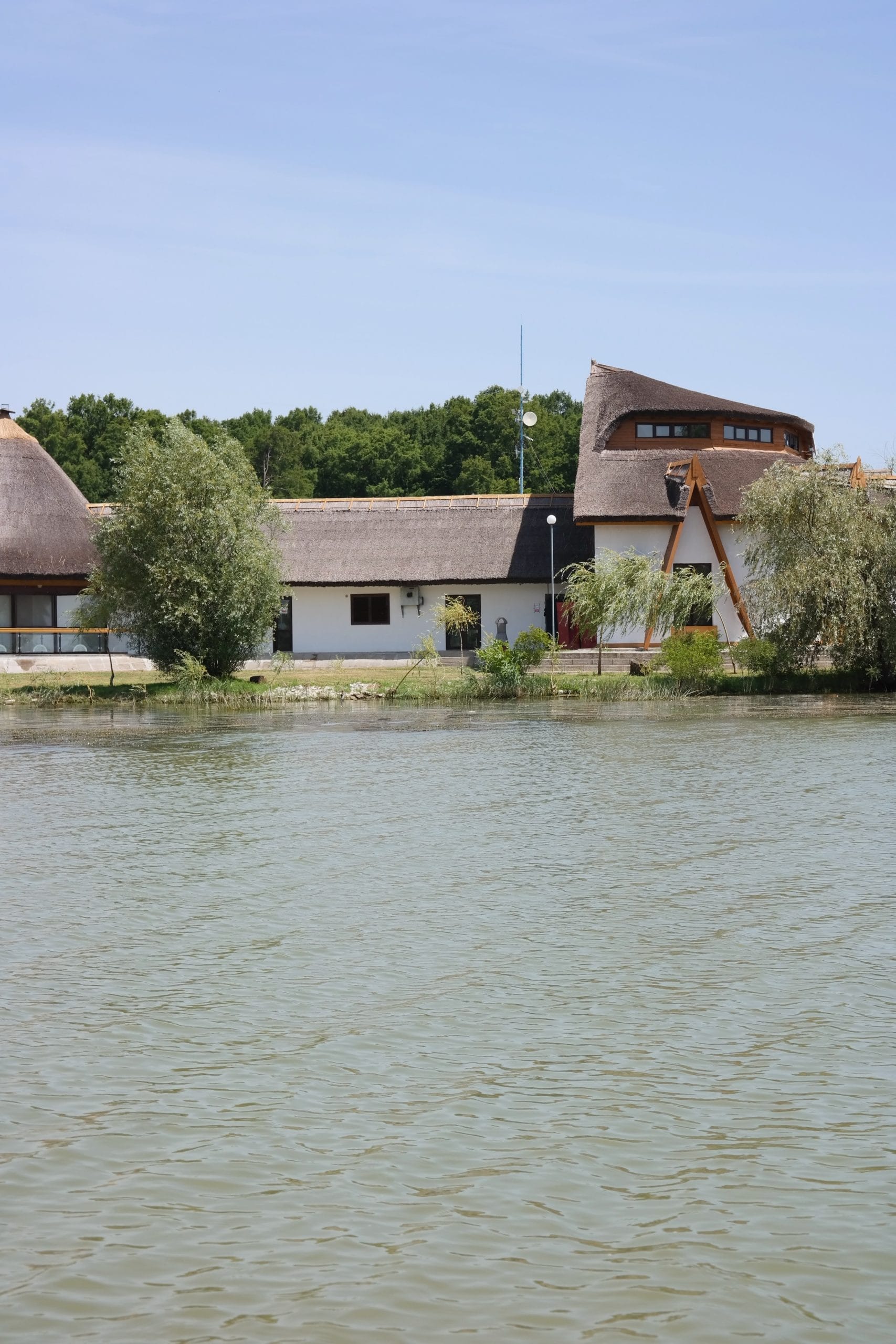 Complex turistic traditional cu acoperis de stuf pe malul apei in Delta Dunarii