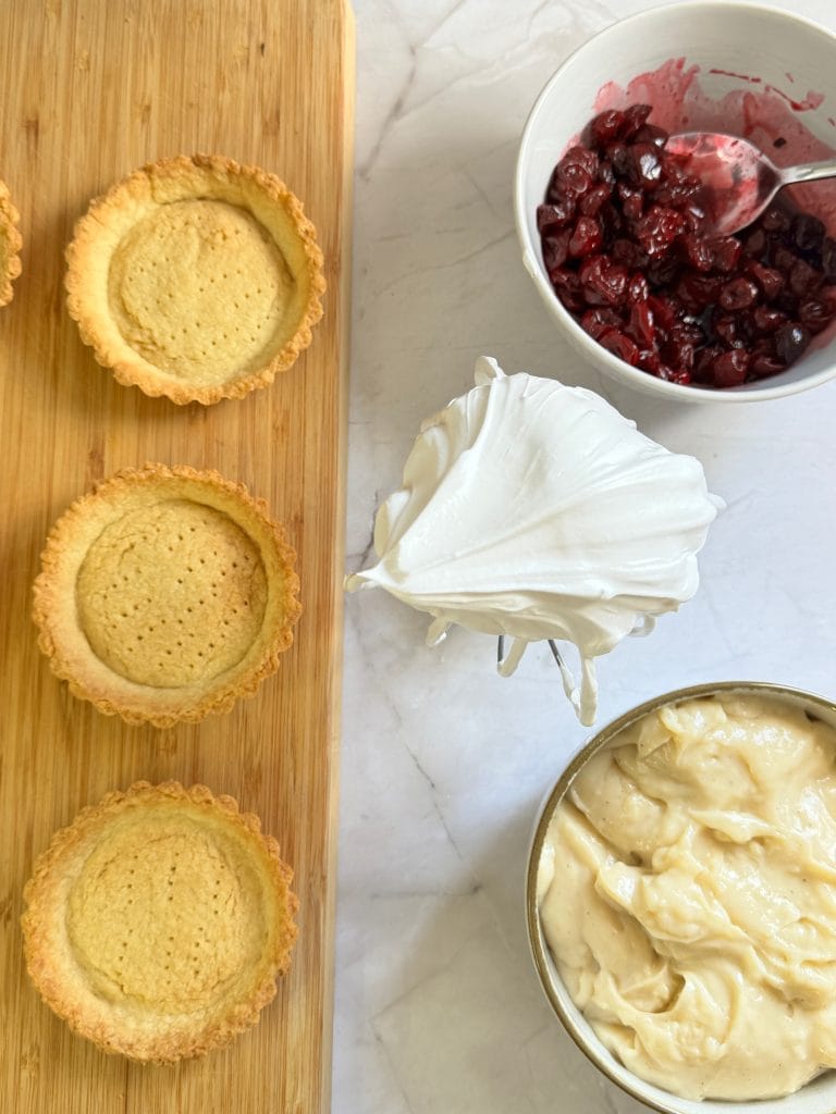 Prepared components ready for assembling mini tarts with meringue and pastry cream