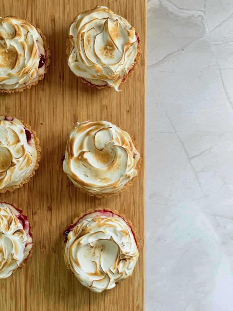Mini tarts topped with golden browned torched Italian meringue