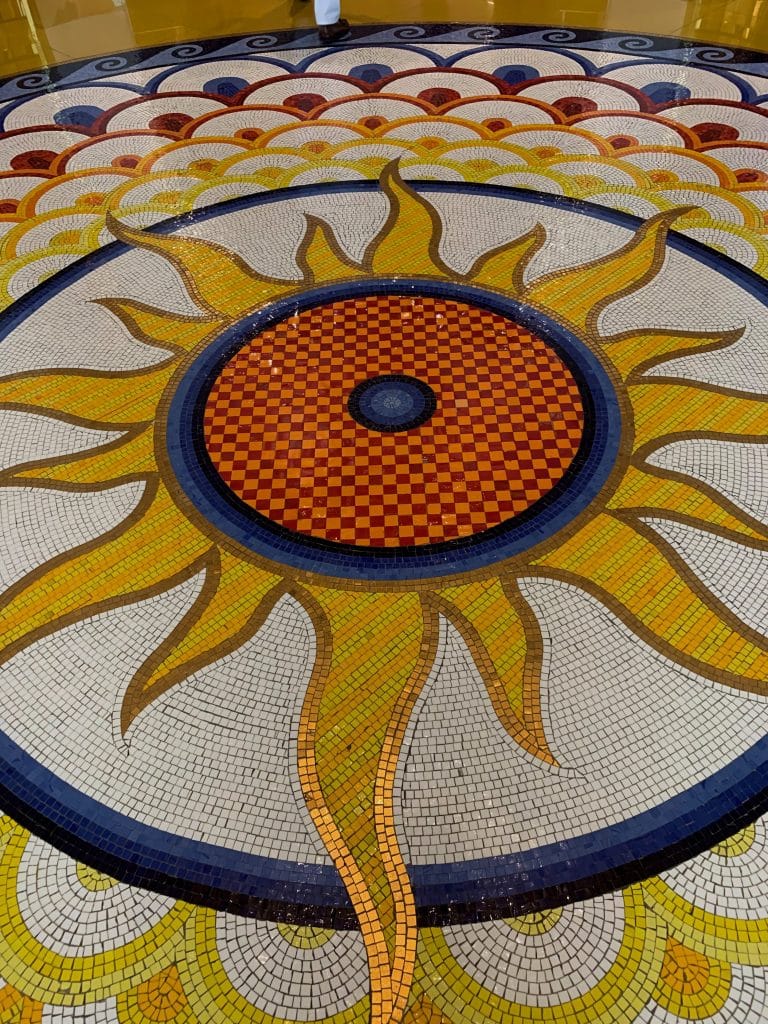 Detaliu cu un mozaic artistic reprezentand un soare stralucitor pe pardoseala hotelului Burj al Arab din Dubai