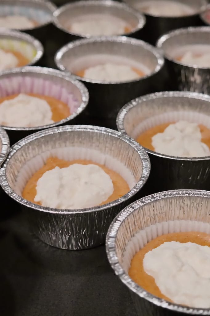 Briose cu dovleac in forme de copt, umplute cu crema de branza inainte de adaugarea crumble-ului