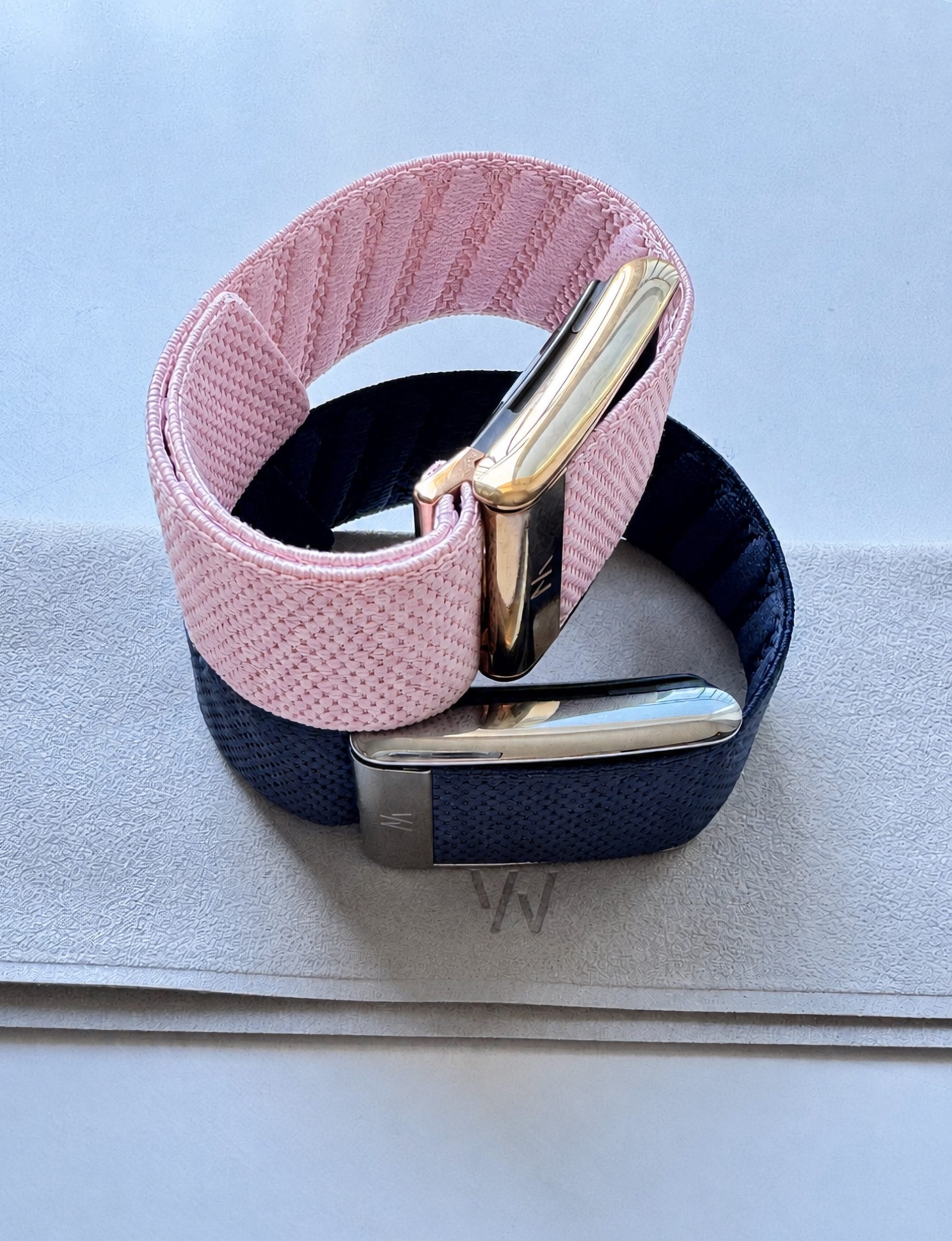 Bratari Whoop cu accesorii textile roz si bleumarin, fotografiate pe un fundal deschis
