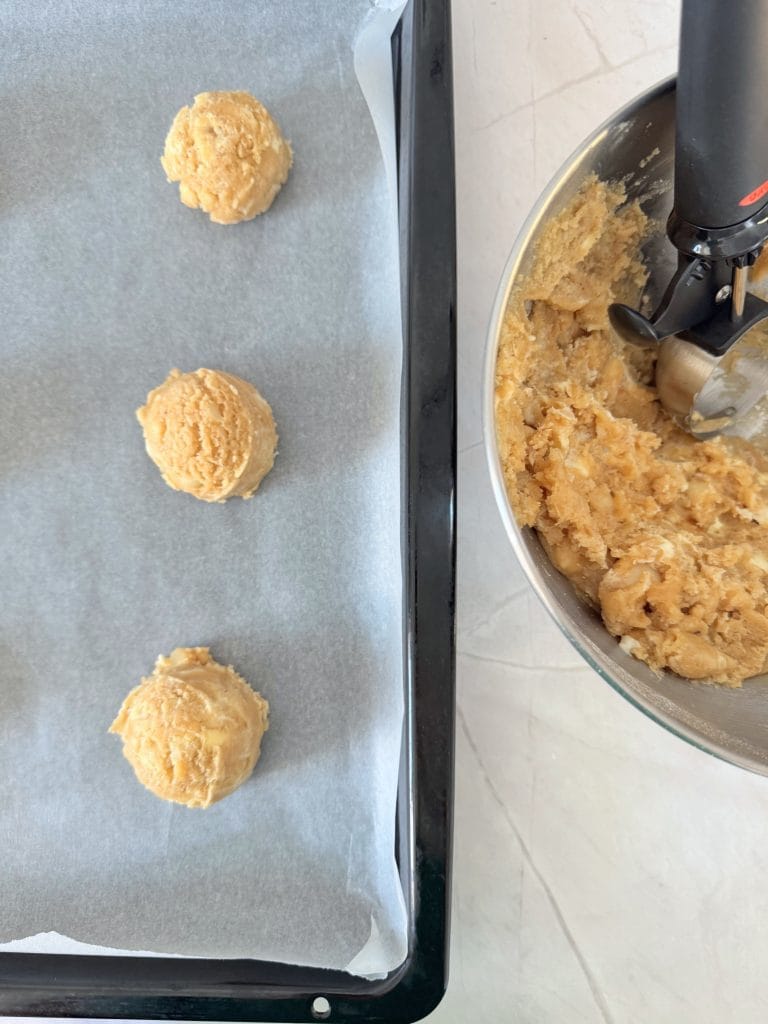 Aluat pentru biscuiți cu unt brun, nuci macadamia și ciocolată albă, porționat în tavă