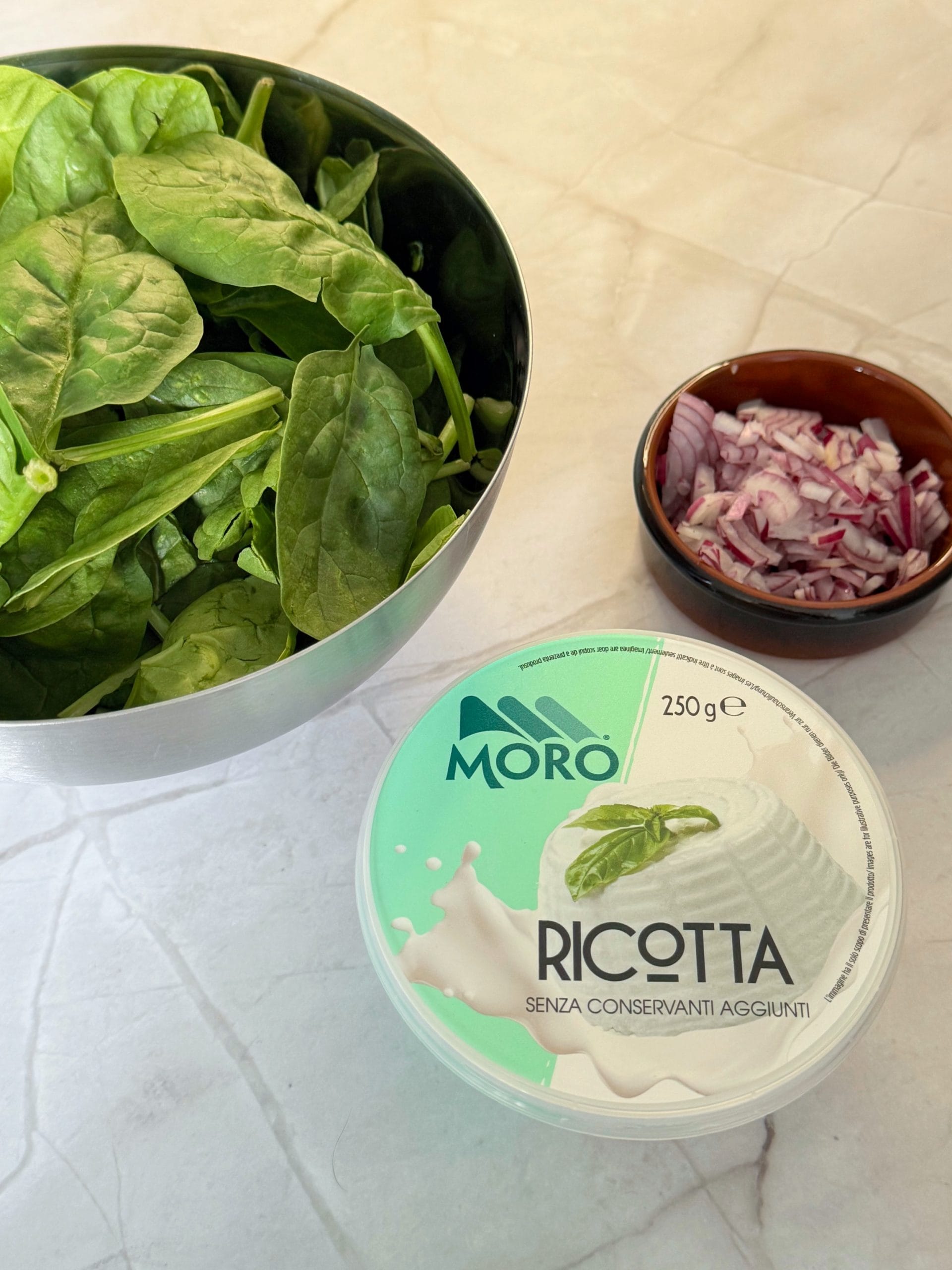 Fresh spinach, chopped red onion and ricotta cheese, ingredients for spinach ricotta cream