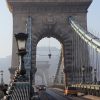 View along the Chain Bridge walkway toward its stone tower and suspension chains
