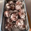 Biscuiți crăpați cu ciocolată neagră, acoperiți cu zahăr pudră și așezați într-o cutie metalică