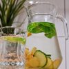 Carafă și pahar cu apă aromatizată, cu frunze de mentă și felii de castravete, lămâie și ghimbir