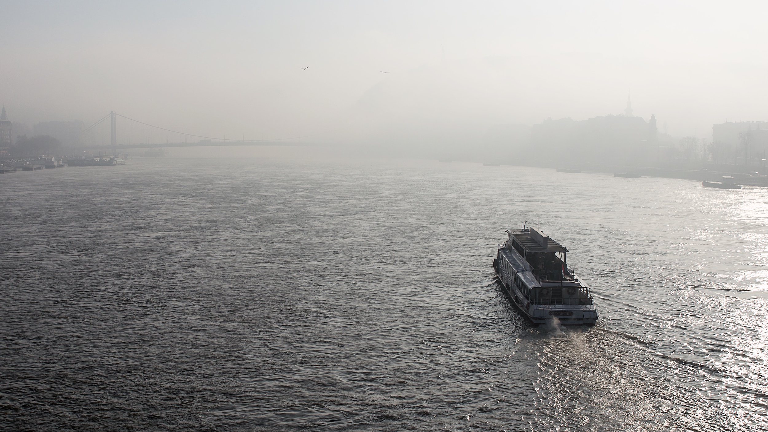 A boat on the Danube, with Budapest’s bridges and riverbanks fading into the winter haze