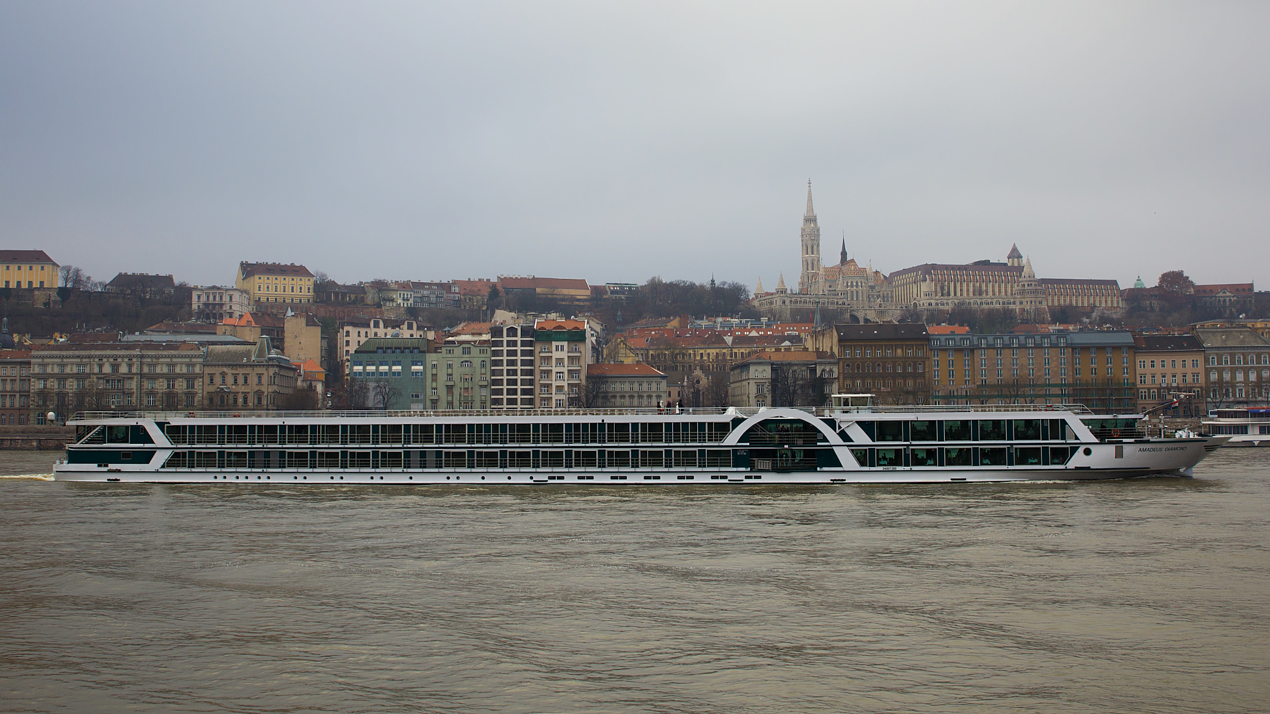 A riverboat on the Danube with Buda’s waterfront and Matthias Church tower behind it