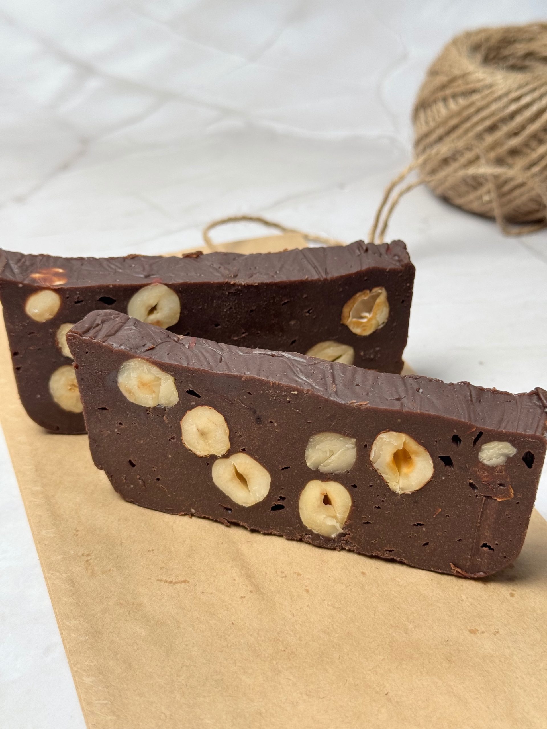 Close-up of two homemade chocolate slices with hazelnuts visible throughout