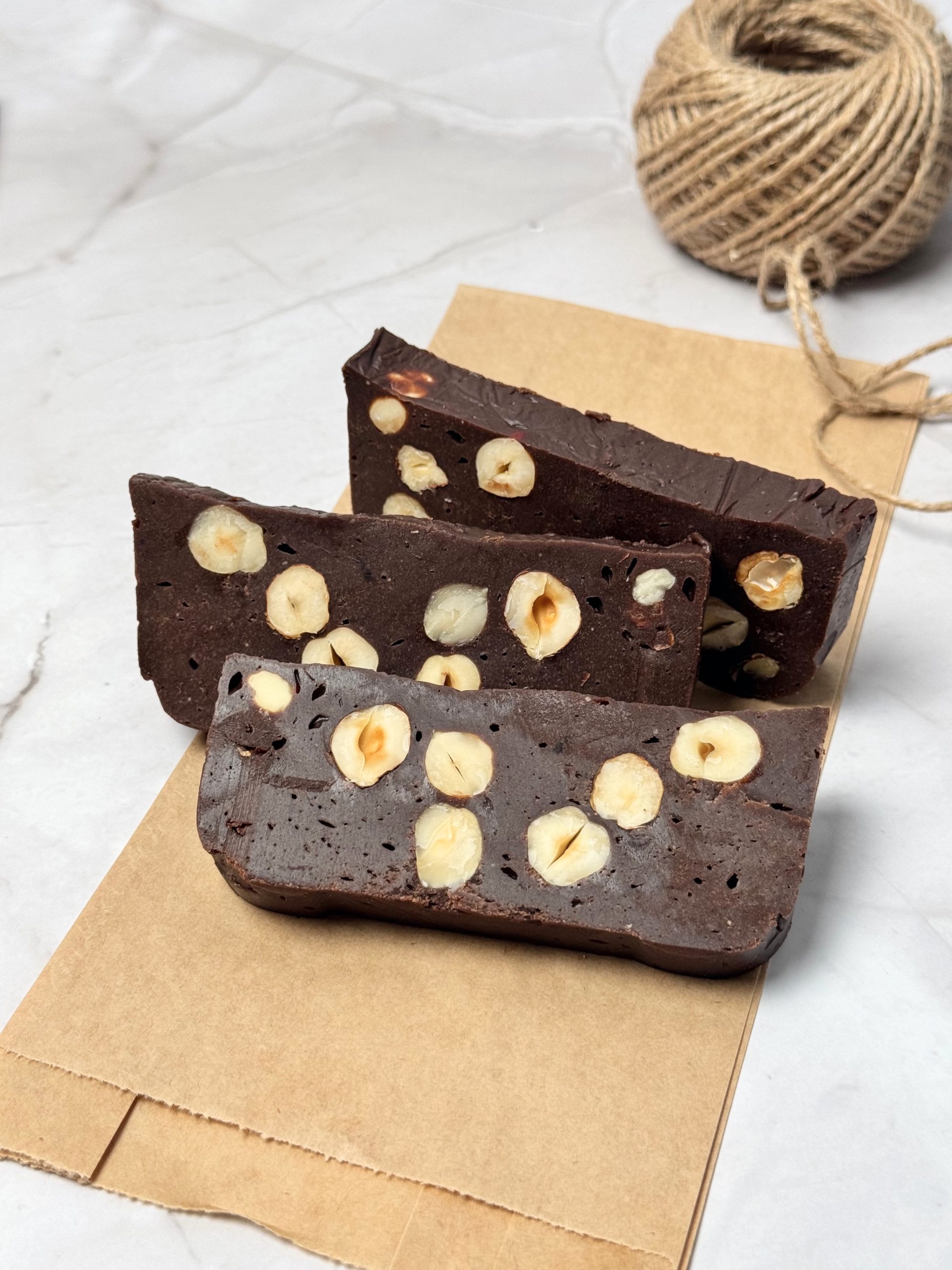 Three slices of homemade hazelnut chocolate arranged on brown paper bag
