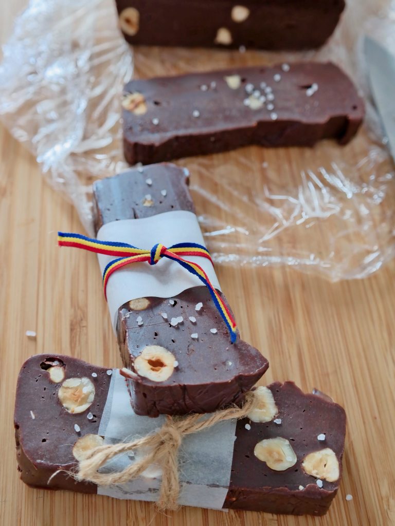 Hazelnut chocolate bars partly wrapped in paper and tied with twine and a Romanian flag's colors ribbon