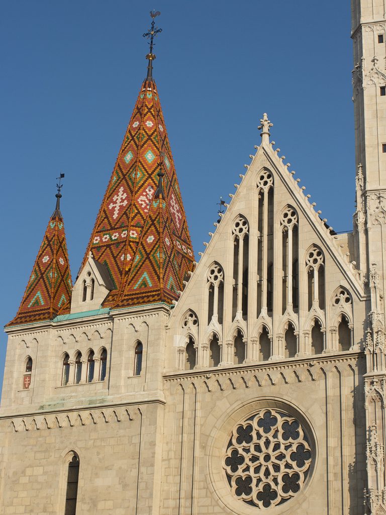 A rose window beneath the patterned roof tiles of Matthias Church