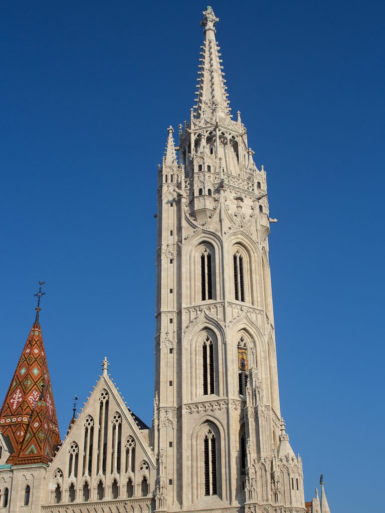 The ornate white Gothic tower of Matthias Church above part of the church façade