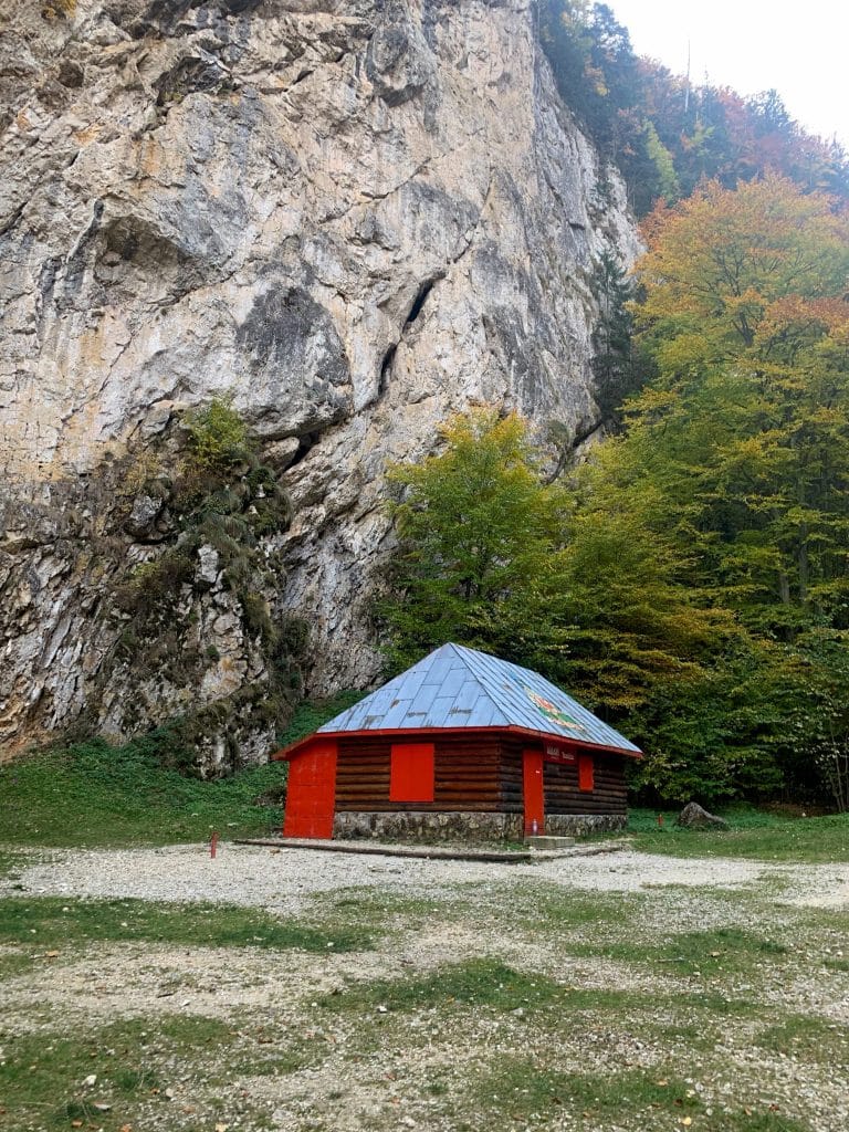 Refugiu din lemn lângă pereții de calcar și pădurea de toamnă din Prăpăstiile Zărneștiului
