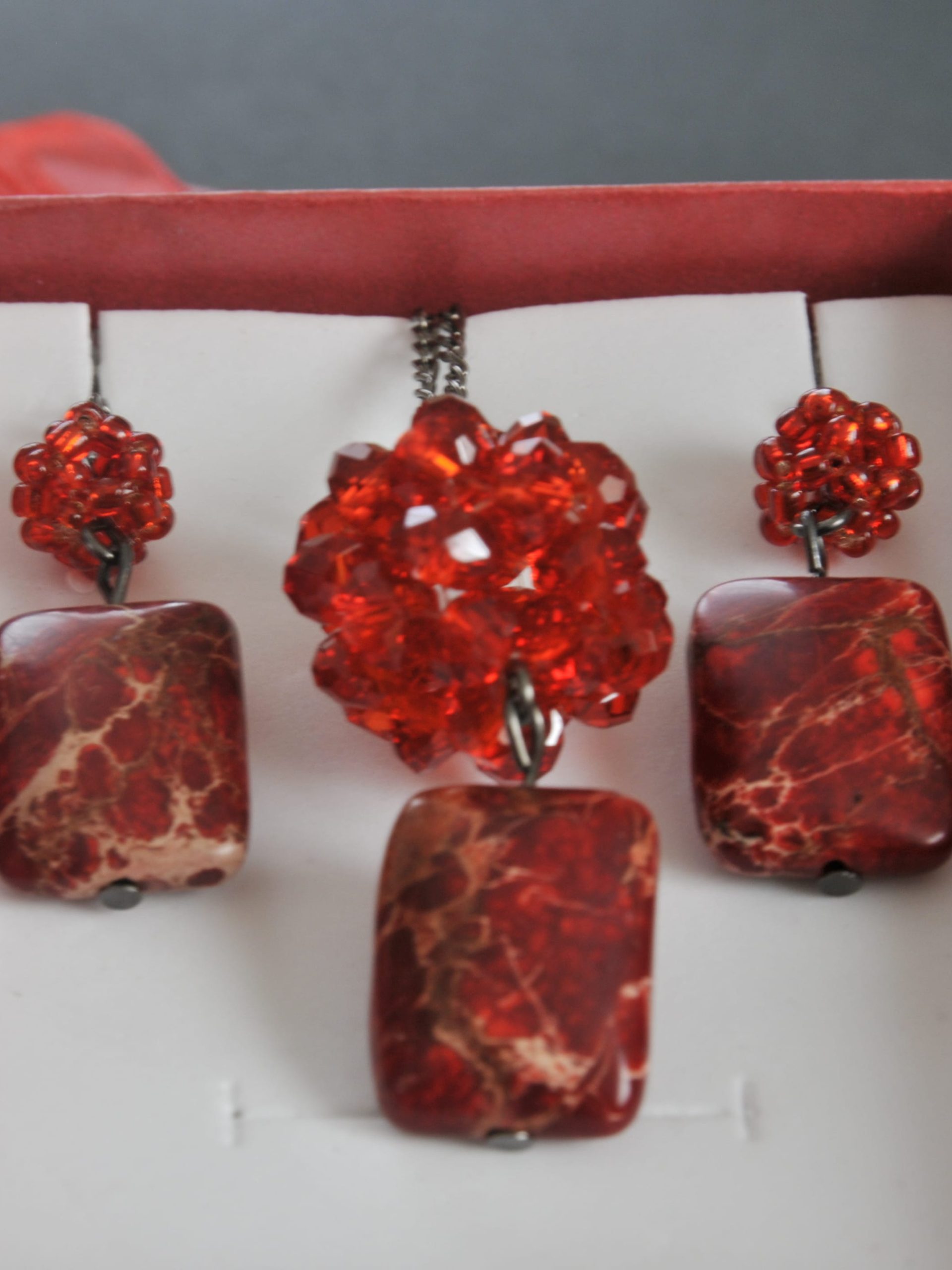 Handmade jewelry set in a red gift box, with two earrings and a pendant made of red crystal beads and rectangular red marbled stones