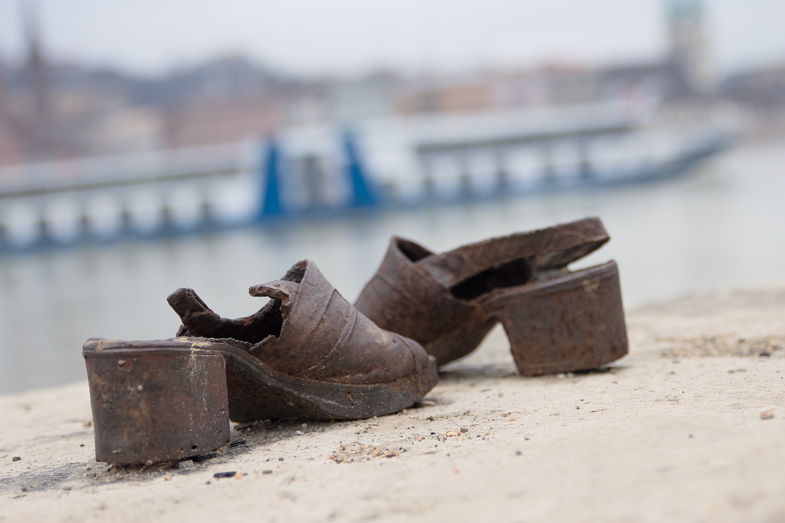 Iron shoes at the Danube memorial, with a riverboat blurred in the background