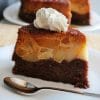 Felie de tort răsturnat cu mere caramelizate, cremă de zahăr ars și blat de cacao, servită cu frișcă