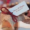 Hexagonal honey jar covered with burlap and tied with a burgundy cord, with a personalized tag, as a wedding favor